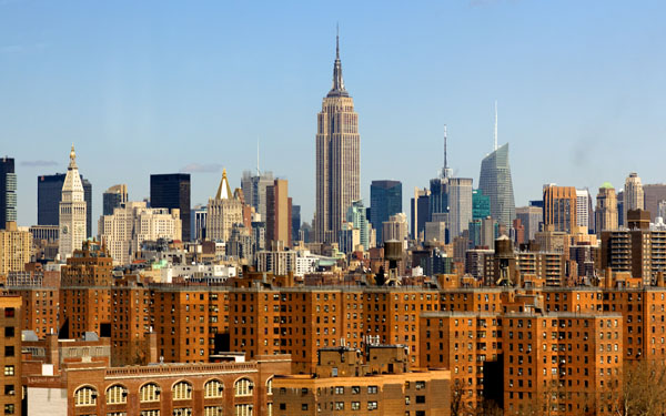 A view of the New York City skyline with low-income housing in the foreground and skyscrapers in the background.