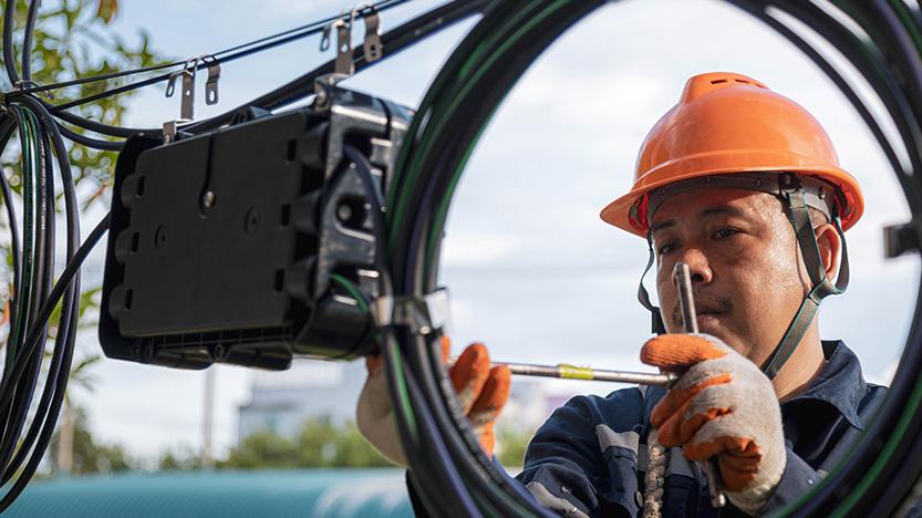 Technician checking fiber optic cable for maintenance. 